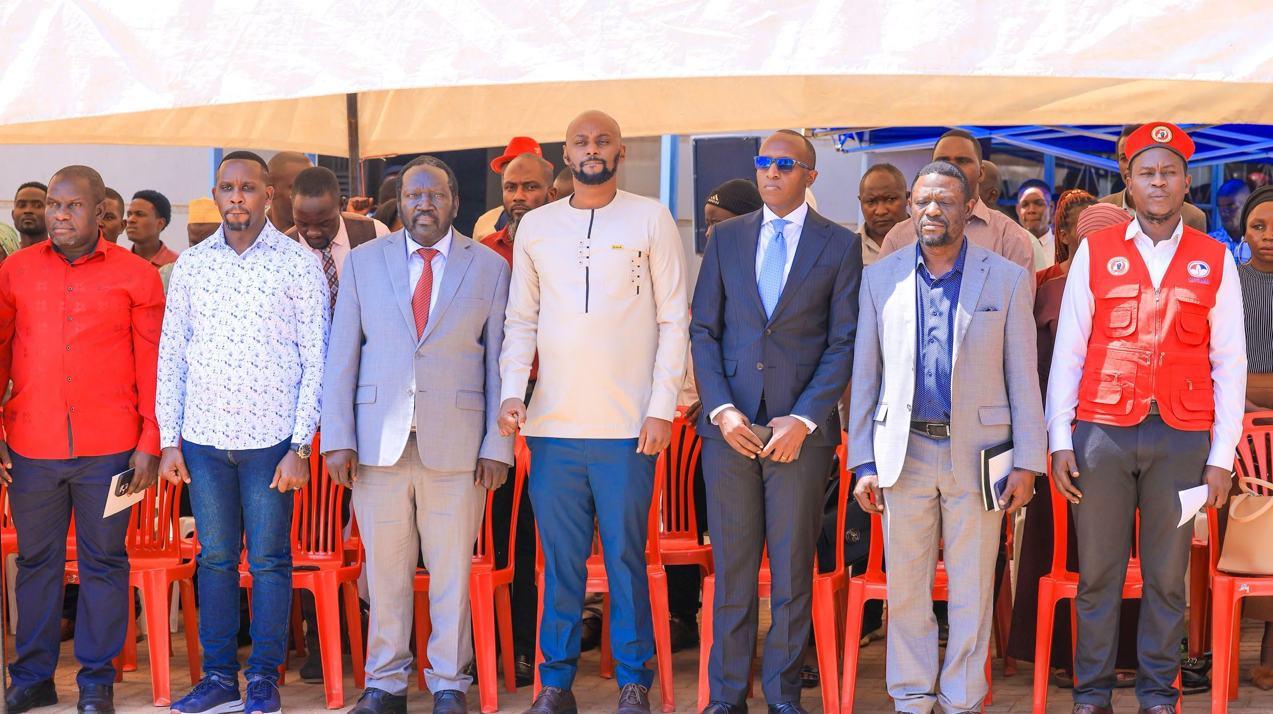 John Baptist Nambeshe with the nine released NUP supporters at a press conference  